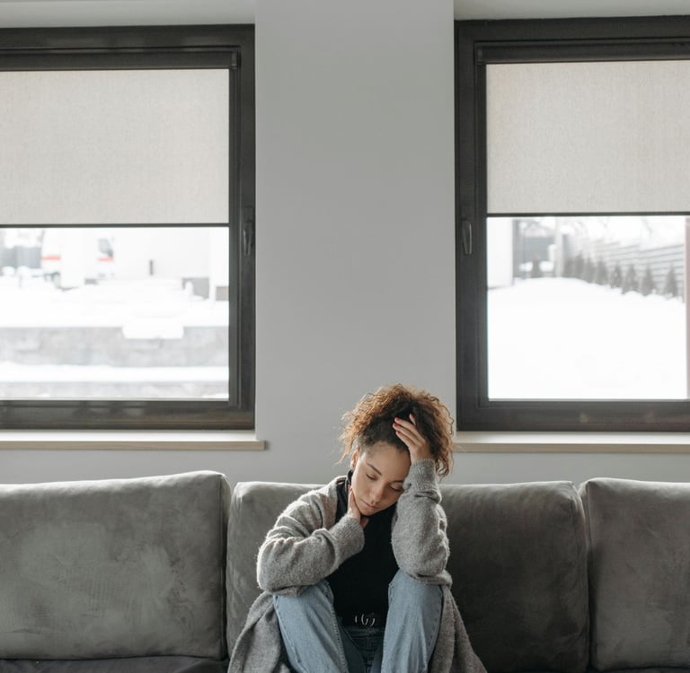 una mujer cansada en un sofá gris