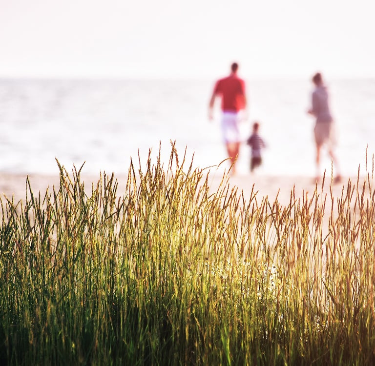 Familie am Strand – Symbol für finanzielle Sicherheit und Vorsorge