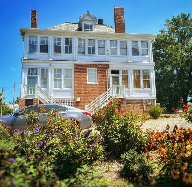 backyard of 2123 Rivermont apartments showing flowers in the foreground and house in background
