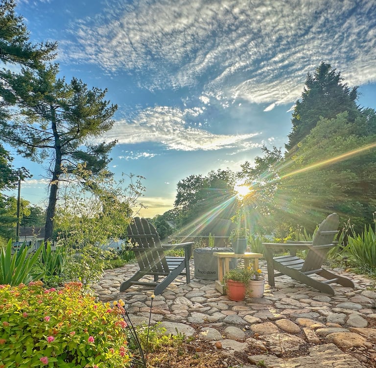 a patio with chairs and a fire pit