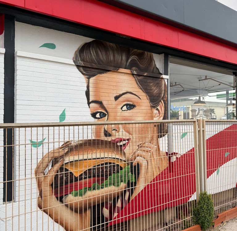 Mural de gran formato sobre fachada urbana realizado con aerosol. Representación figurativa que comb