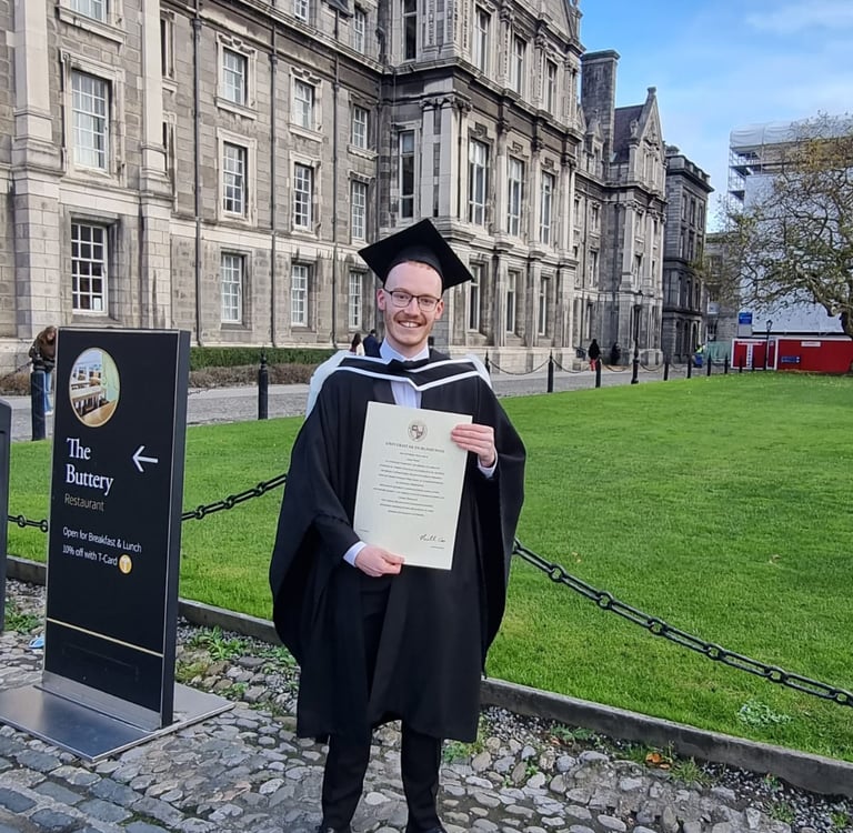 a man in a graduation gown holding a diploma certificate