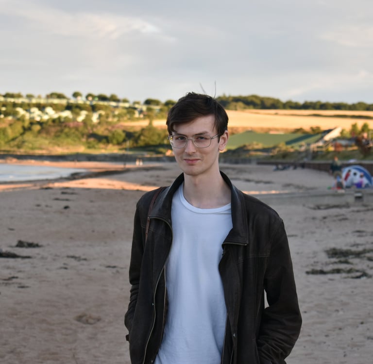 a man standing on a beach with a surfboard