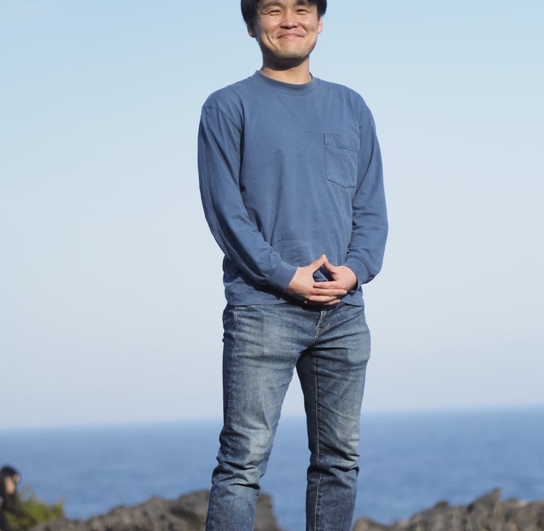 a man standing on a rock with his hands on his hips