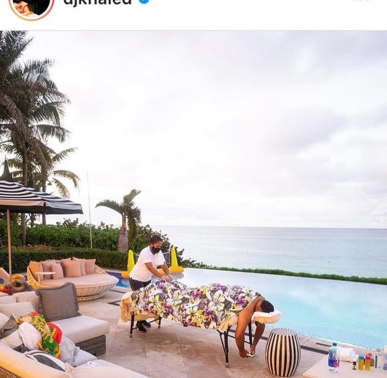 dj khaled having a massage by massages by sophia in front of a pool