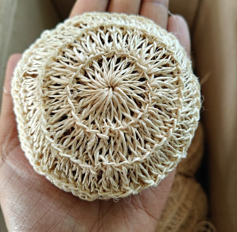 Hand-held eco-friendly sisal fiber scrubbing sponge for natural dishwashing and plastic-free cleaning.