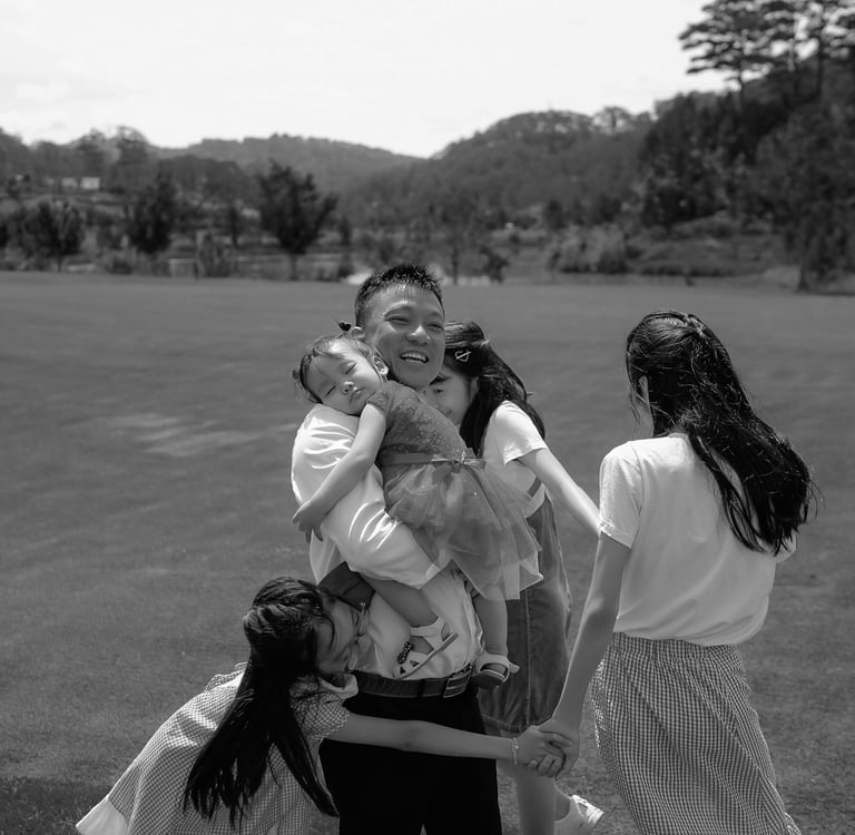 a family of four people standing around a woman holding a baby