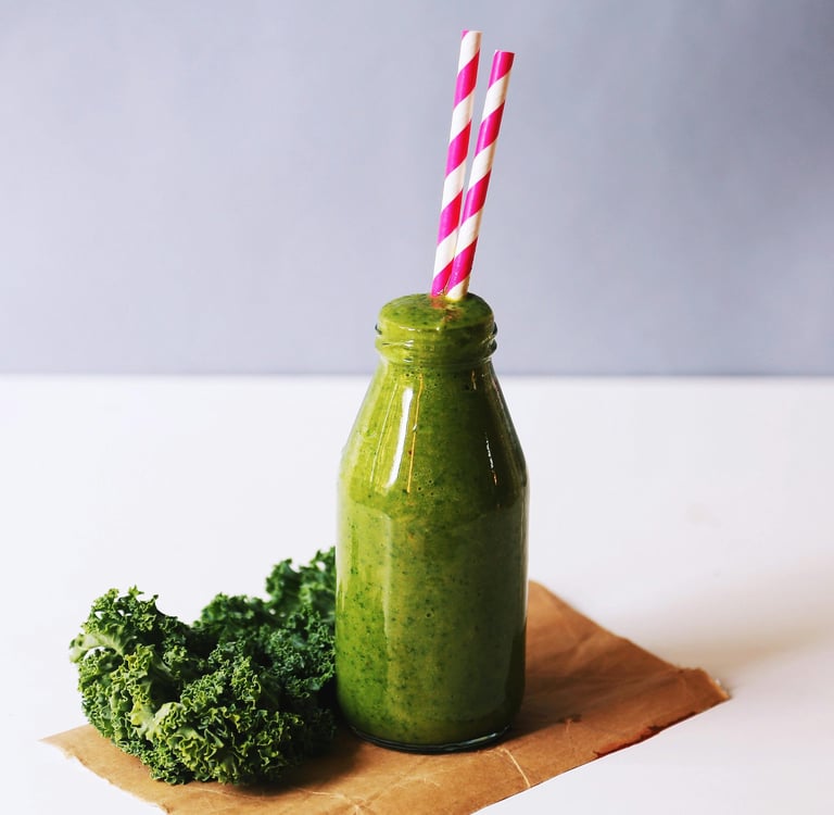 a bottle of green smoothie with a strawberries and a strawberries