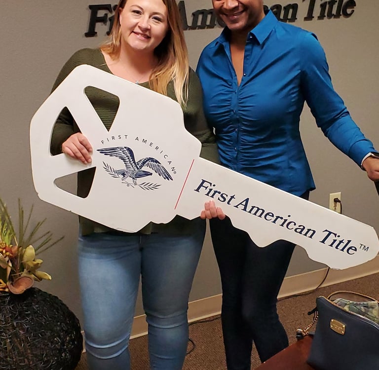 two women standing next to each other holding a sign