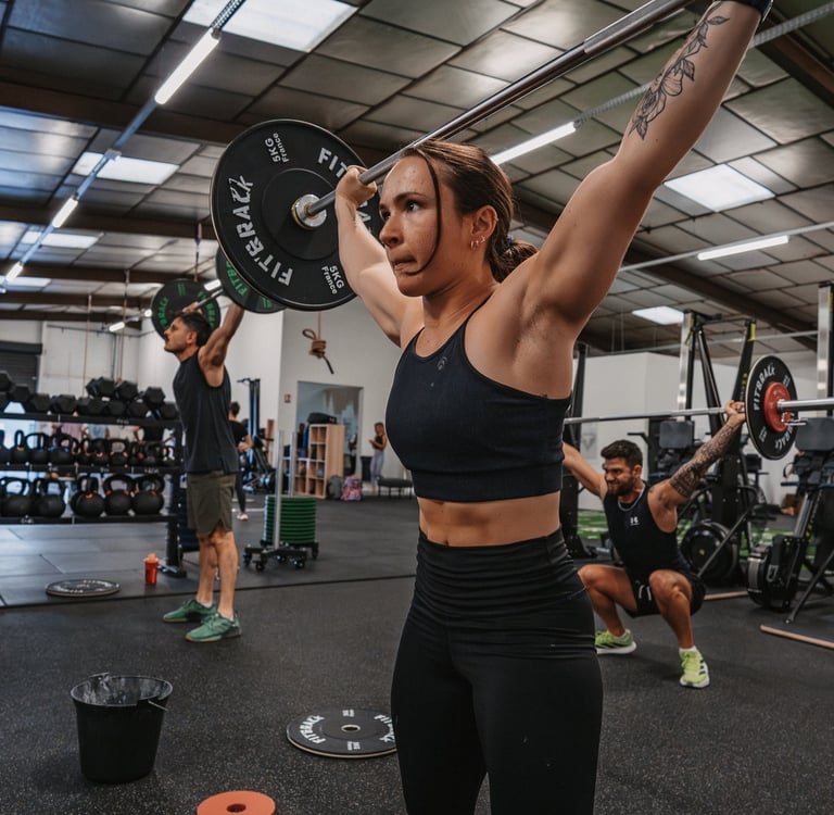 Jeune femme réalisant un exercice de Crossfit, dans sa salle de sport à Pau, au nord-est de la ville
