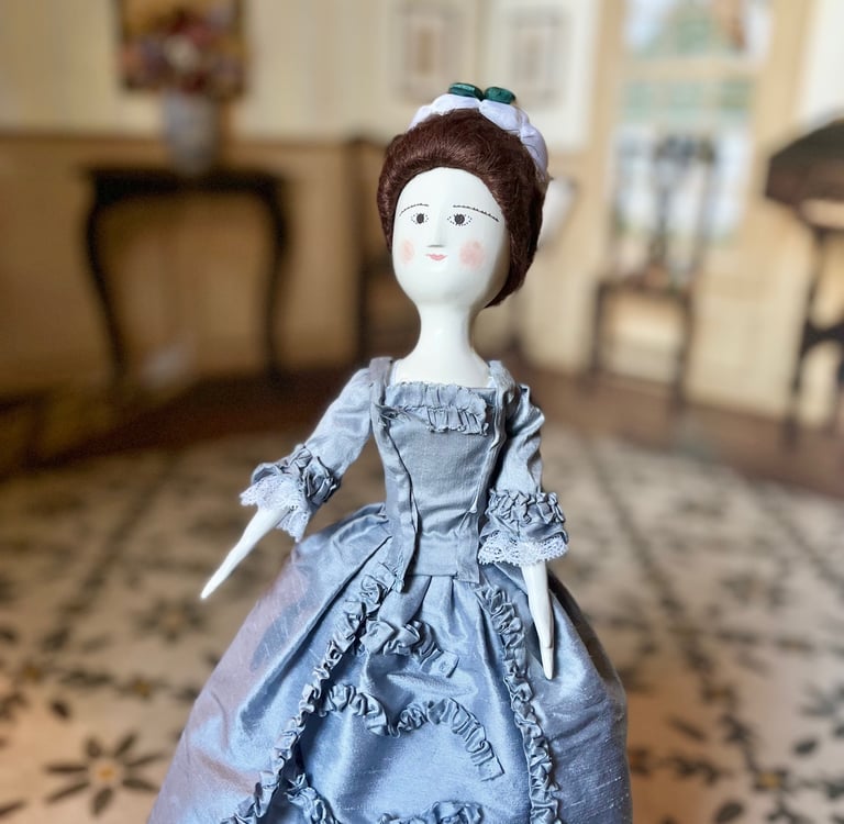 a wooden doll in a blue dress