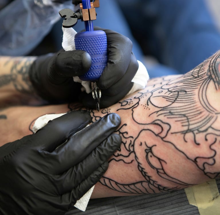 Tatuador desenvolvendo sua arte no braço de um cliente