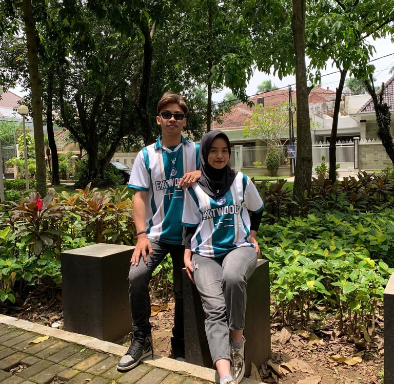 a man and woman sitting on a bench in a park