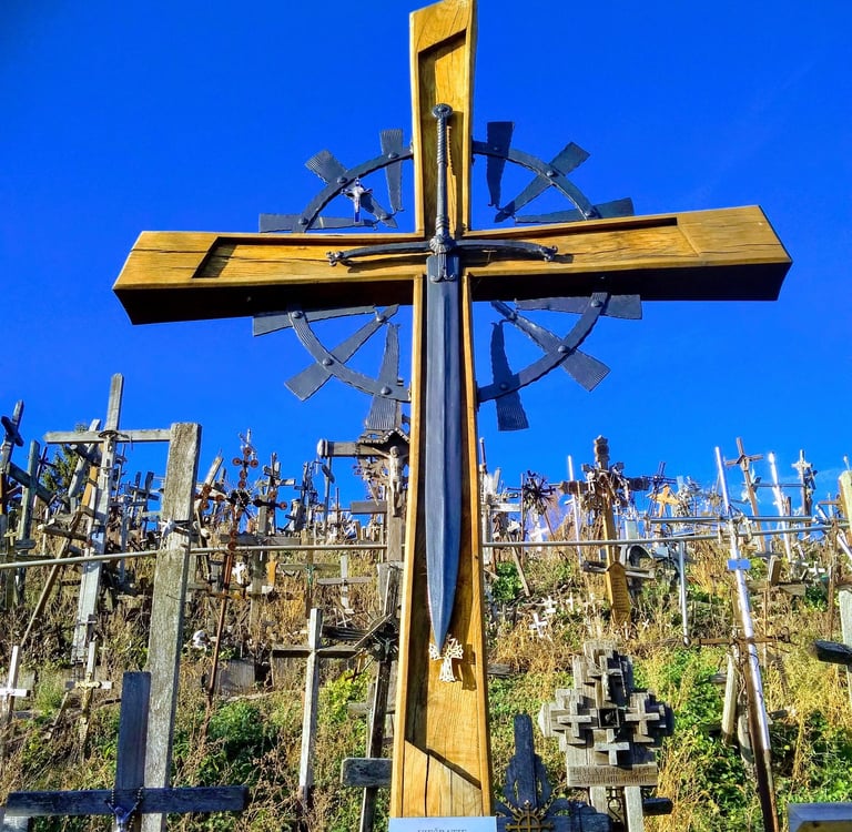 A large wooden cross with an inlaid sword at the Hill of Crosses pilgrimage site in Lithuania.