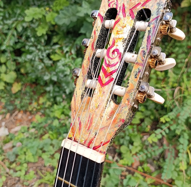détail de Suun, une peinture sur guitare aux couleurs vives et contrastées - tête de la guitare