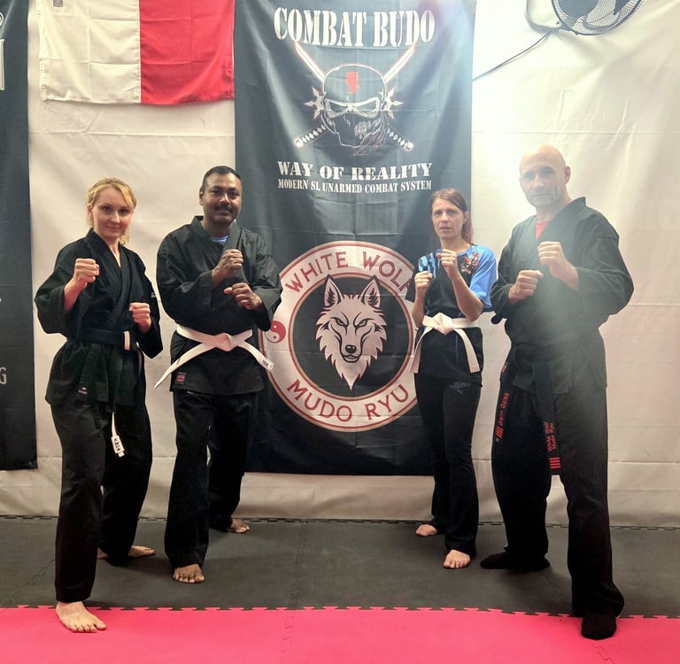 Martial arts practitioners in black gi uniforms posing in a Combat Budo Mudo Ryu training gym.