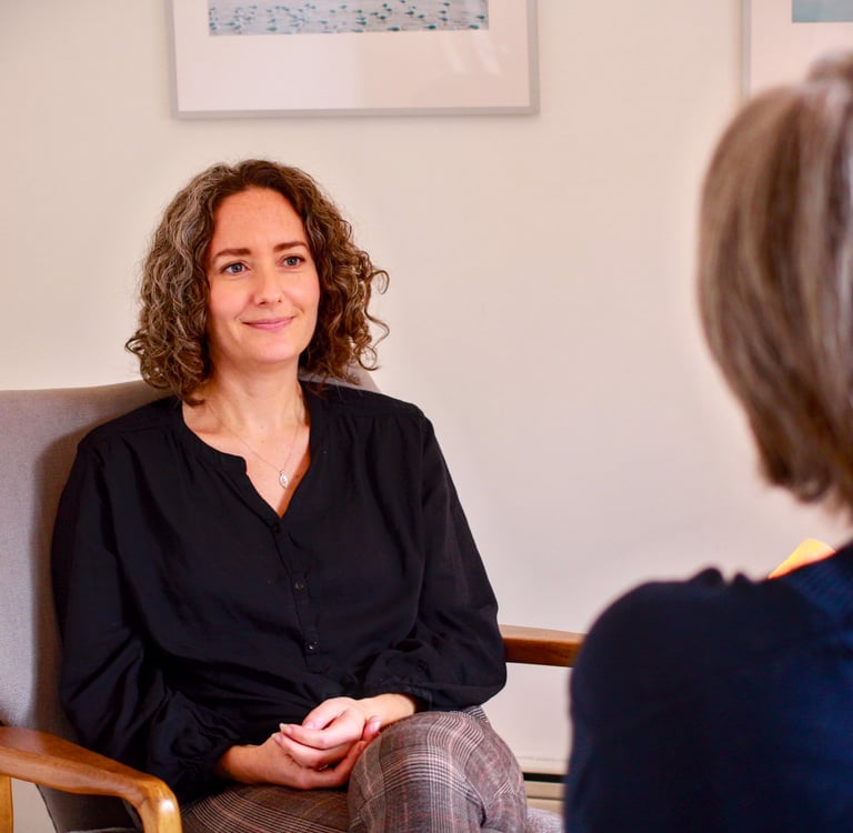 Female therapist with a relaxed and calm demeanor sits across from client 