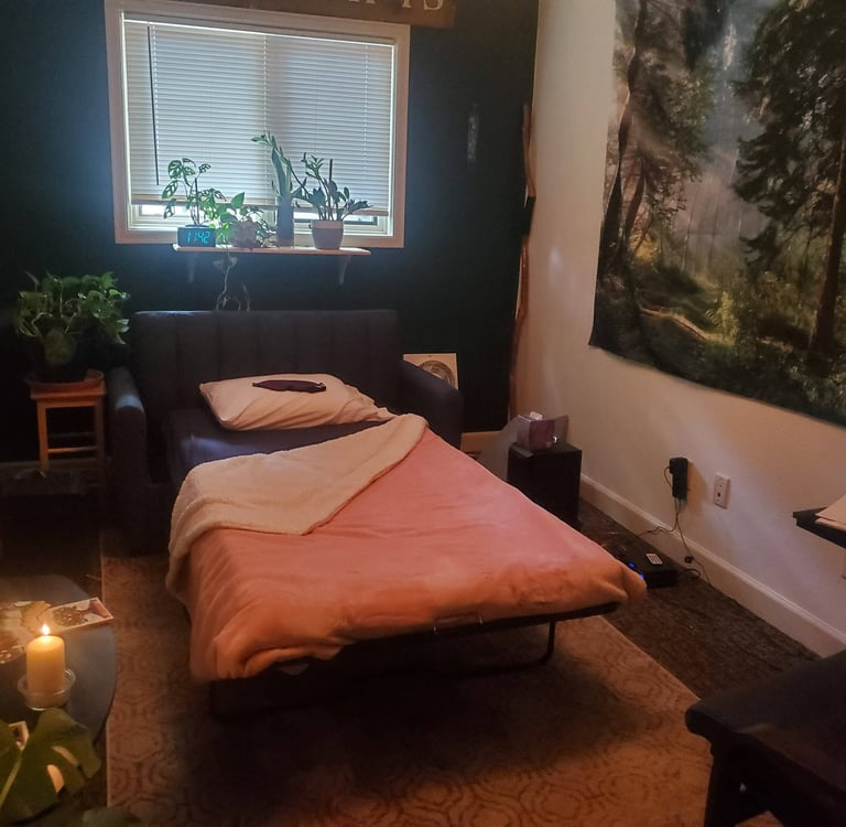 A psychedelic therapy room, set up with a bed, candles, speakers, plants and artwork