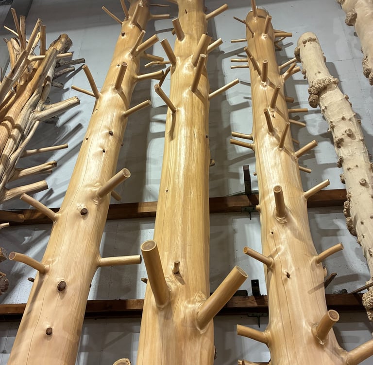 Polished natural wood log columns with decorative branch stubs for rustic timber interior design.