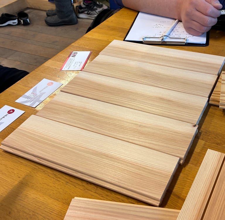 Natural sugi wood panelling samples displayed on a table for home renovation project planning.