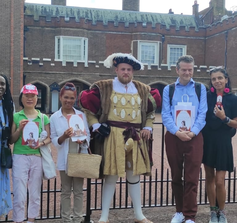 a group of people standing in front of St James's Palace with Henry VIII