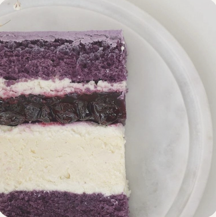 a piece of cake with a purple and white background