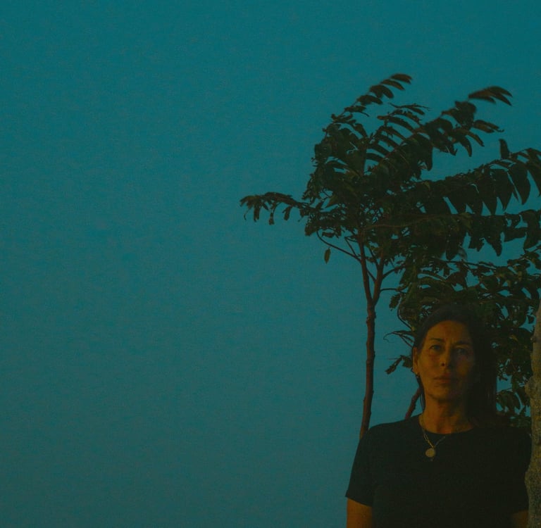 a woman standing in front of a tree