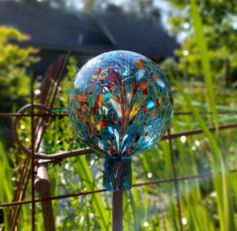 Ankes glaskulor framför en dam i trädgård aqua