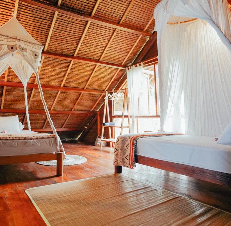 Cozy double bedroom in Toska Surf House with canopy bed and wooden interiors