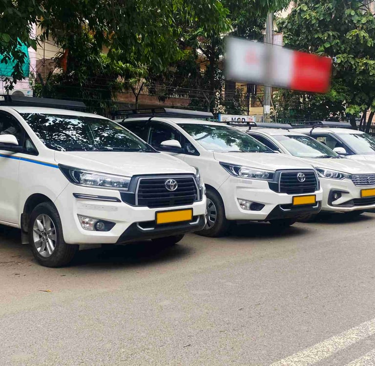 A row of white Toyota Innova Crysta taxis parked on a city street for commercial rental services.