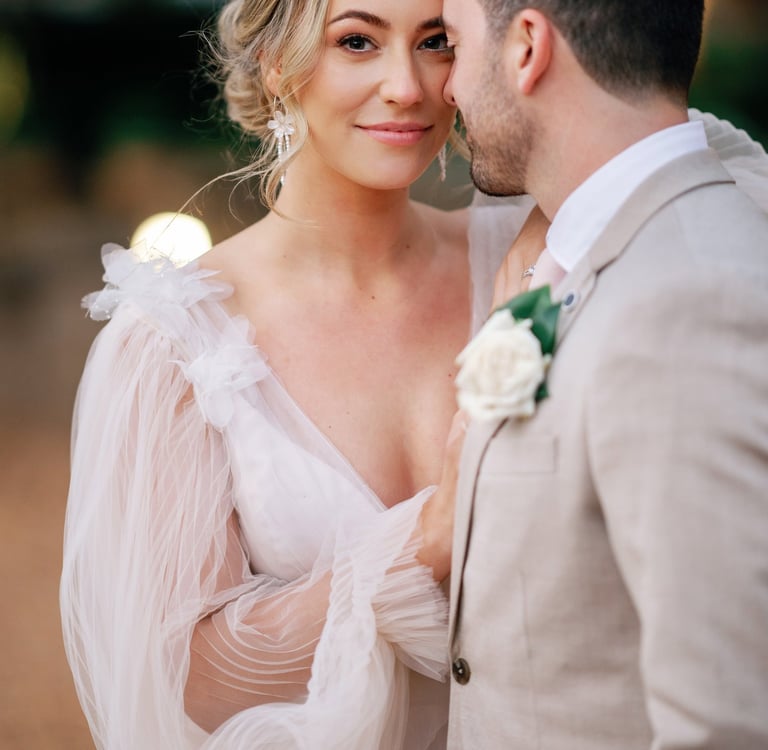 a bride and groom standing in front of a tree