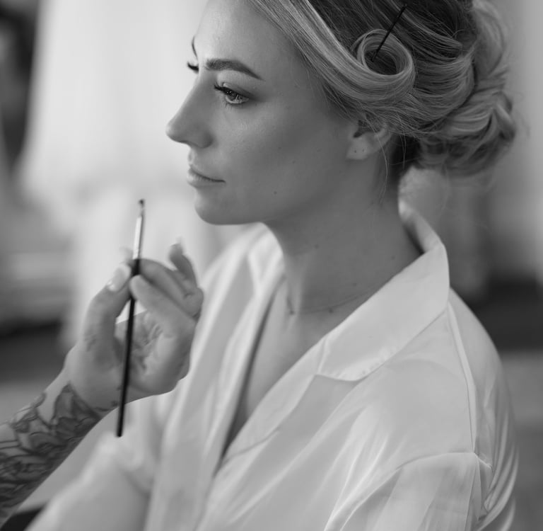 a woman getting makeup done by a professional makeup artist