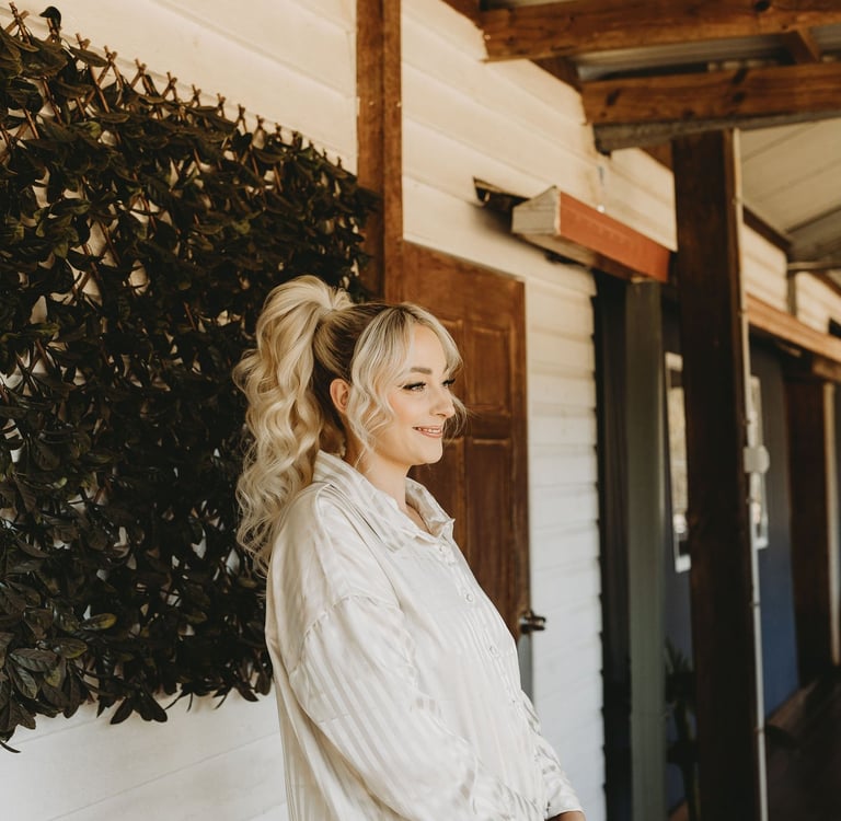 a woman standing in front of a wall with a planter