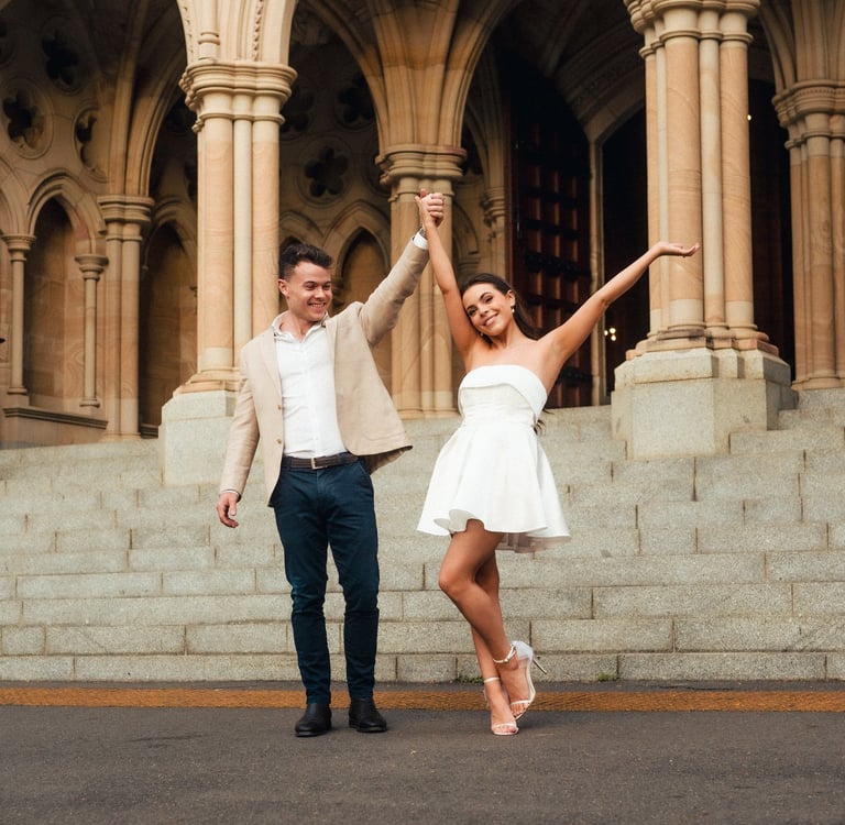a man and woman dancing in front of a building