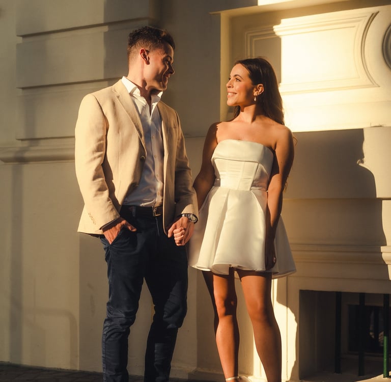 a man and woman holding hands and walking down a cobblestone