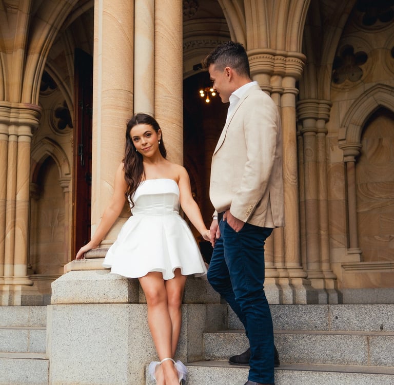 a man and woman standing on stairs in front of a building