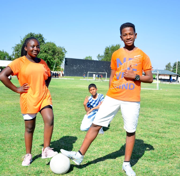 two young men playing soccer on a field