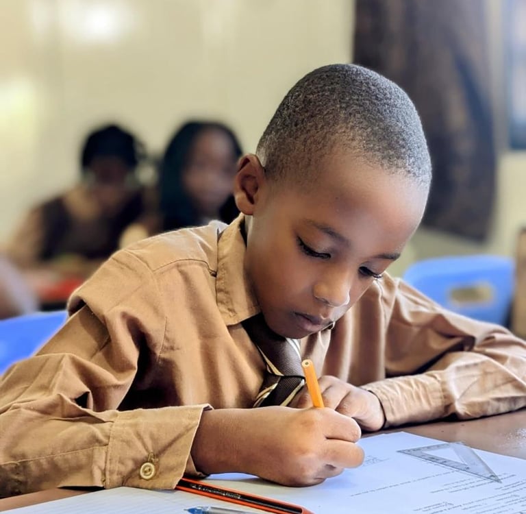 a young boy is sitting at a desk with a pencil and pencil