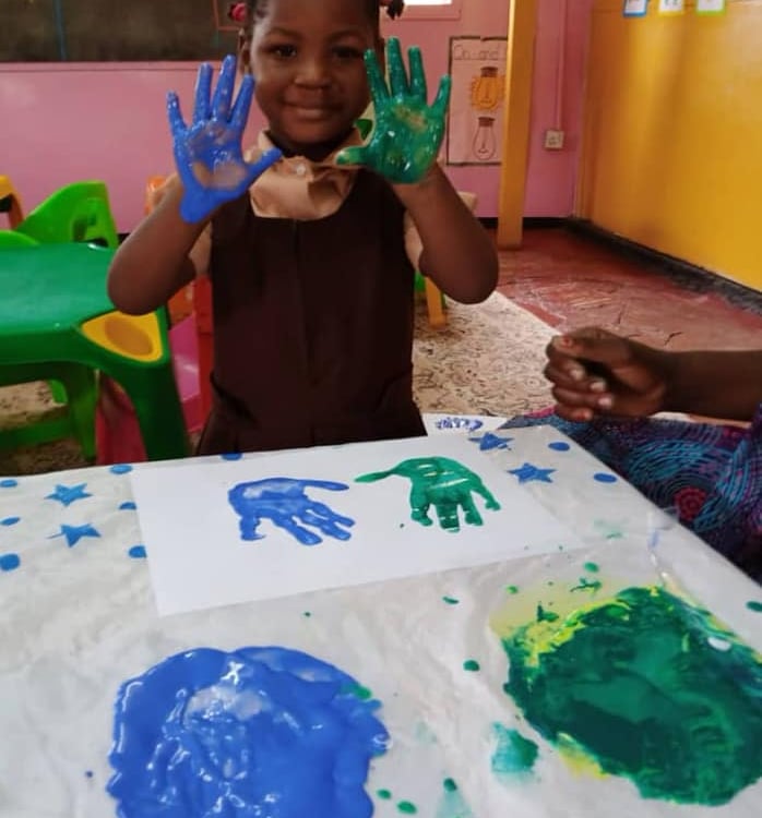 a child's hands painted with blue and green paint
