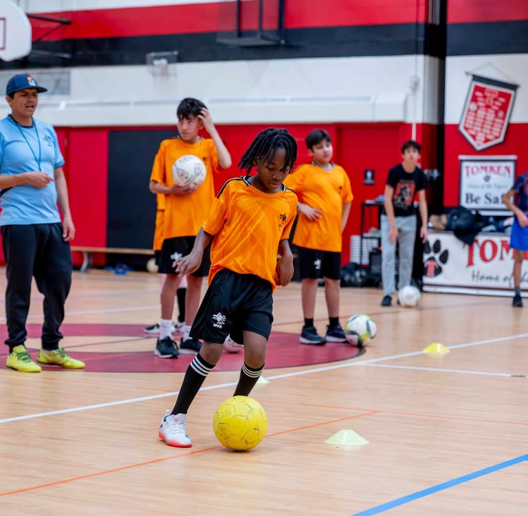 MBV FC Soccer player practices soccer ball dribbling drills at an indoor soccer class.
