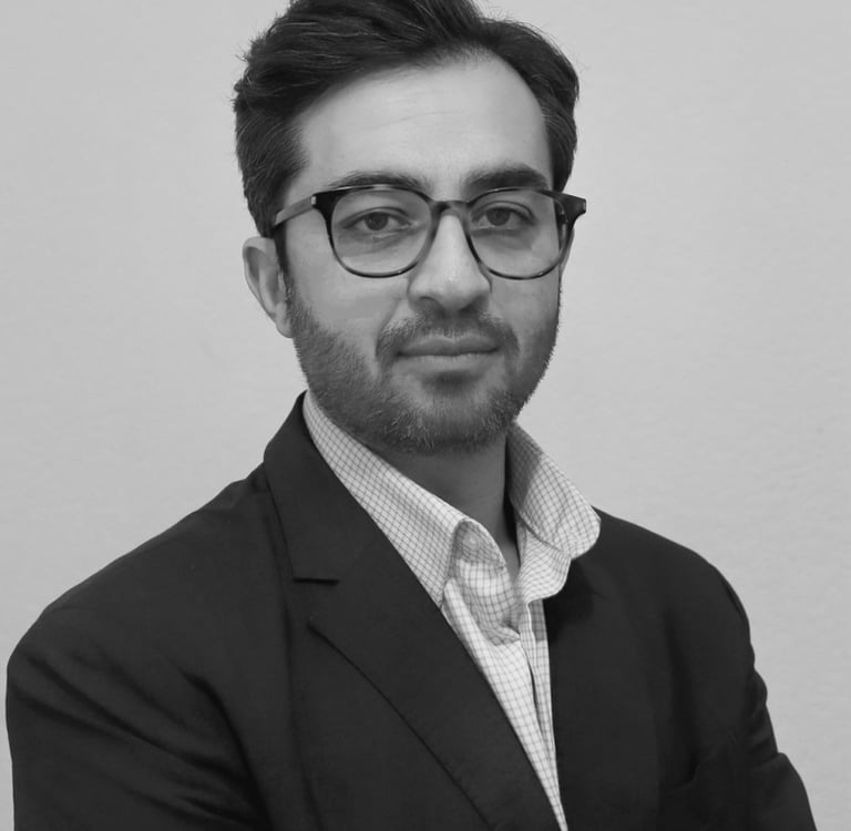a man in a suit and glasses posing for a picture