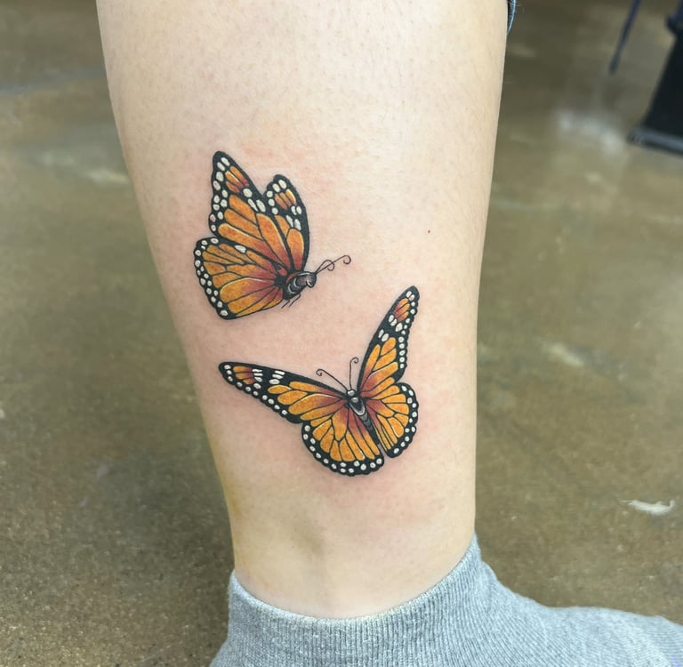 a butterfly tattoo on the leg of a woman's leg