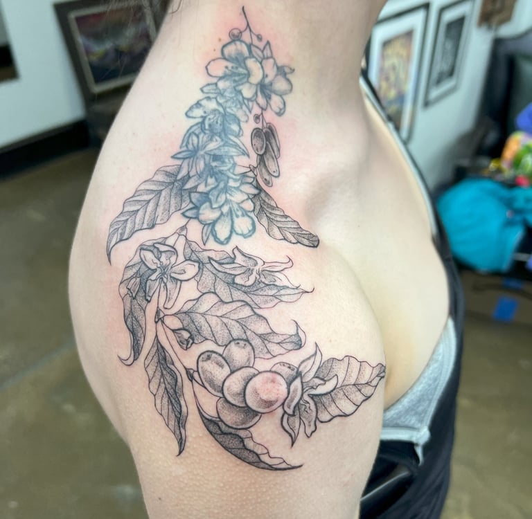 a woman with a tattoo on her chest and shoulder delicate leaf design