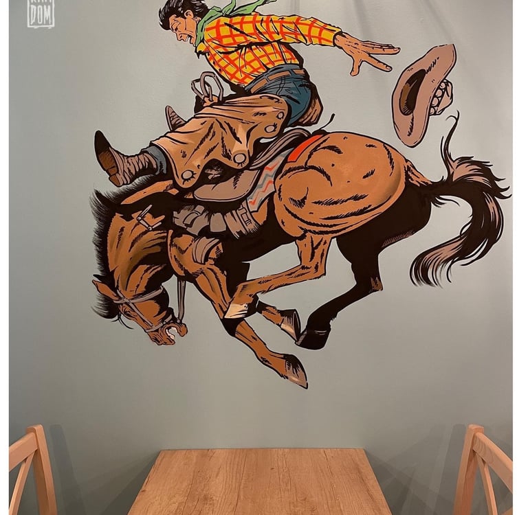 mural de un baquero a caballo en una pared de un restaurante