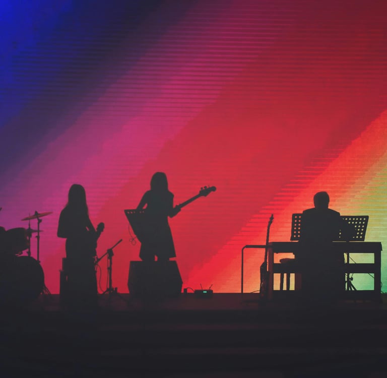 band on stage with rainbow background on screen