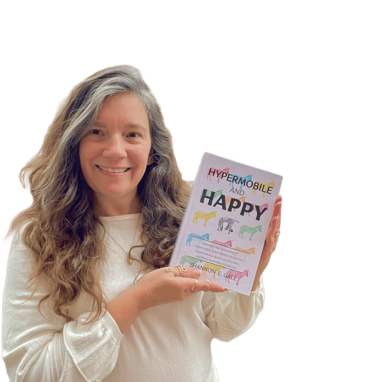 smiling woman with long brown hair and white sweater holding a book