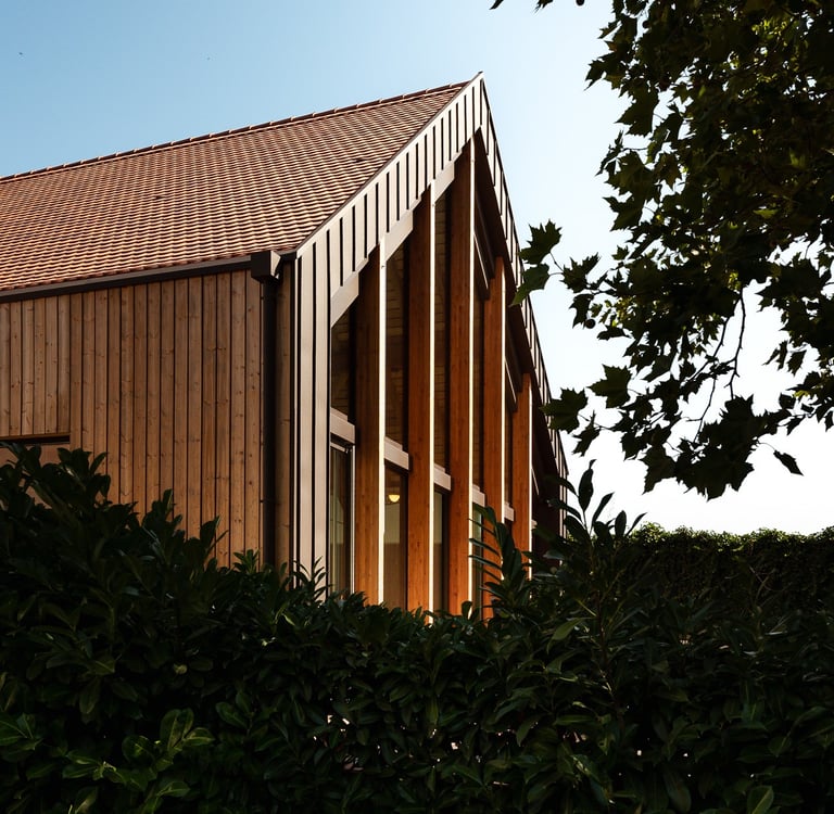 a building with a clock towering over a hedge