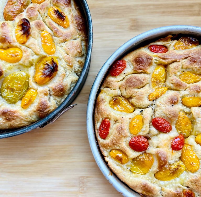 focaccia baked and presented on the mold with market tomatoes