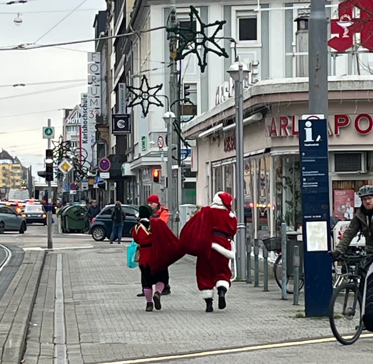 Santa and his elf walking a street in Karlsruhe