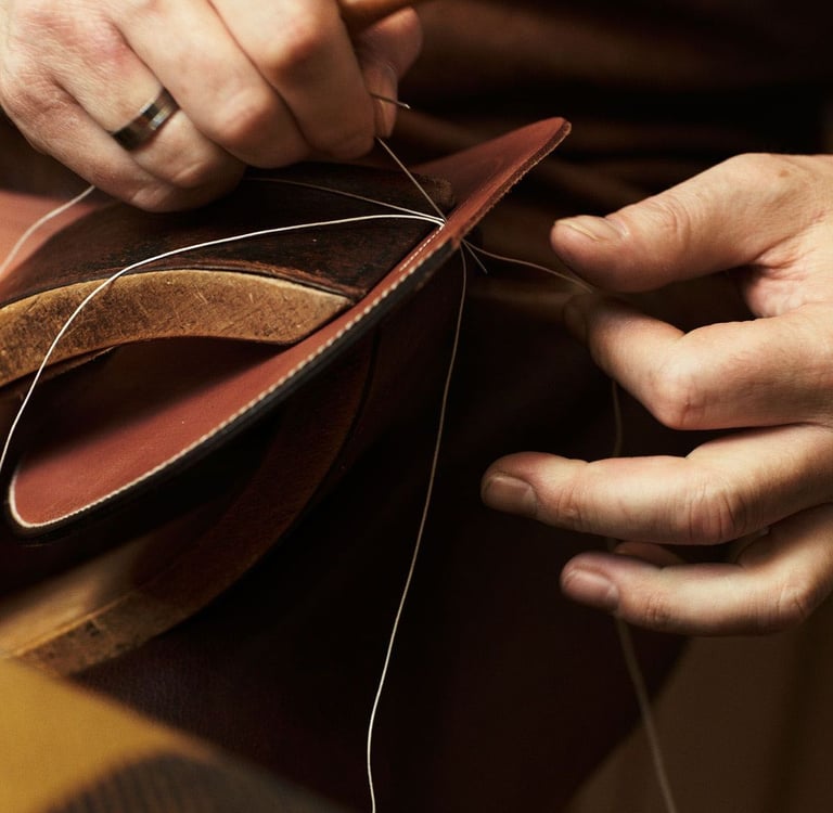 Artisan hand-stitching leather, luxury craftsmanship.